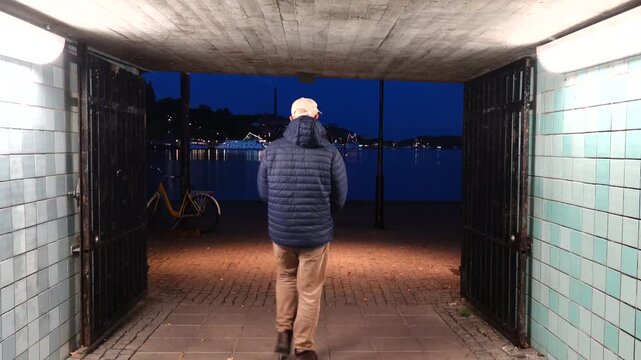 Stockholm, Sweden A man walks in a corridor leading to the Riddarfjarden bay at night in Gamla Stan, or Old Town. 