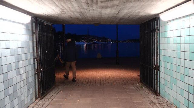 Stockholm, Sweden A man walks in a corridor leading to the Riddarfjarden bay at night in Gamla Stan, or Old Town. 