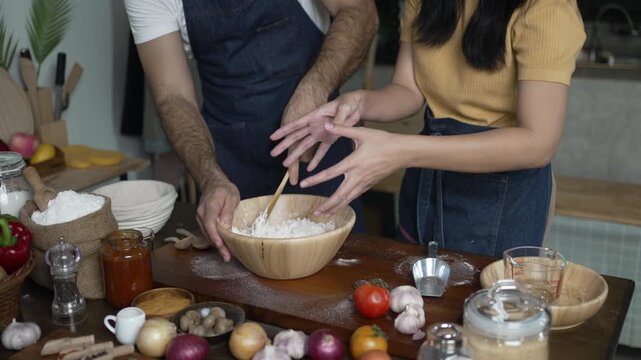Man and Woman Mix Flour Together in Wooden Bowl