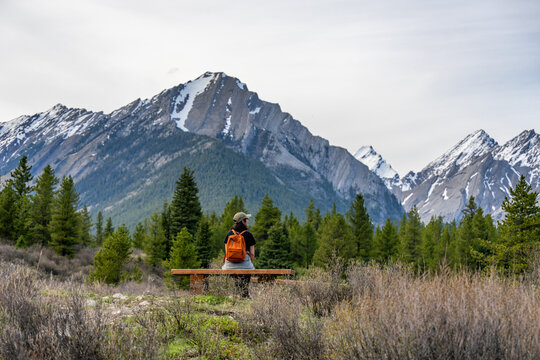 Woman sitting on a bench admiring a scenic mountain view