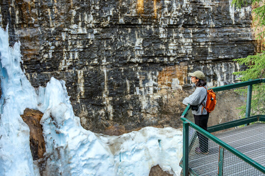 Woman standing on viewing platform looking at Johnston Canyon in Banff