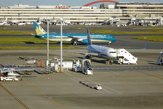 日本東京，2023年10月30日：国際羽田空港滑走路上の到着便のターミナル移動駐機旅客機交差模様