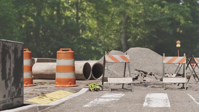 Under construction background, wide view of roadwork site with concrete pipes and traffic cones. 3d animation.