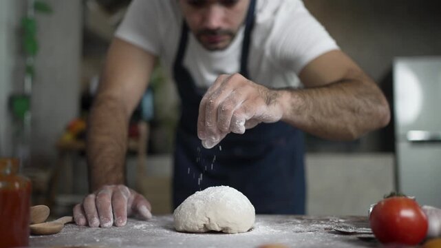 Bearded Man Sprinkles Flour Onto Pizza Dough