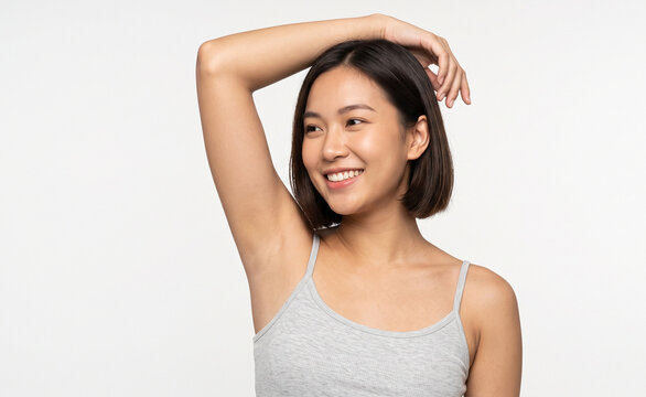 Confident young woman lifting arm and showing smooth clean armpit