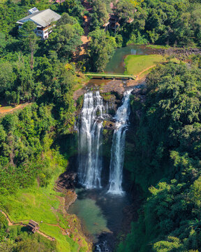 Aerial drone view of Tad Gneuang Waterfall in Laos, a spectacular tropical cascade surrounded by dense rainforest on the scenic Bolaven Plateau in Champasak Province.