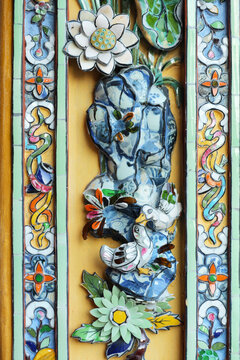 Traditional porcelain lotus flower and mandarin ducks mosaic on ancient vertical border panel, oriental ceramic shards artwork relief design