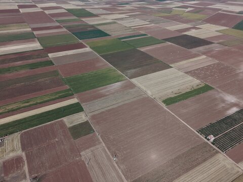 Aerial top-down view of colorful patchwork agricultural fields and geometric farm plots