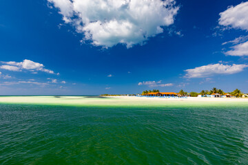 Tropical sandy beach and an exotic view of the Atlantic Ocean against a blue sky with clouds in Cuba, Caribbean – background for projects, wallpaper © anettastar
