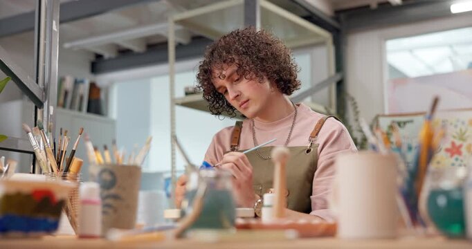 Pottery, art or man in workshop with painting, ceramic craft or color decoration in creative hobby. Product, pattern and artisan with paintbrush, design process or clay creation in handcraft activity