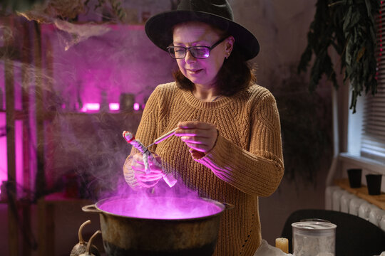 realistic witch holding voodoo doll casts spell brewing potion in cauldron. Everyday life intertwined with traditional witchcraft, magic and mystical atmosphere.
