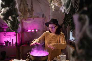 realistic witch witchcrafting, casting spells brewing potion in cauldron. Everyday life intertwined with traditional witchcraft, magic and mystical atmosphere. © Andrii Lysenko