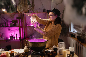 realistic witch witchcrafting brewing potion in cauldron. Everyday life intertwined with traditional witchcraft, magic and mystical atmosphere. © Andrii Lysenko