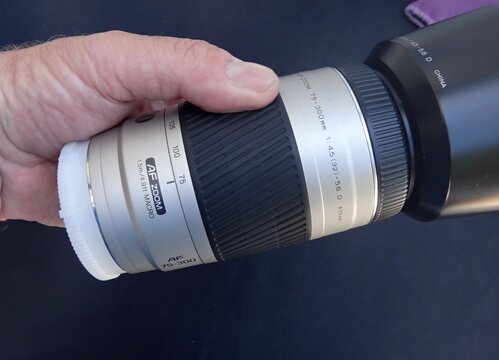 Hand holding AF zoom camera lens close-up