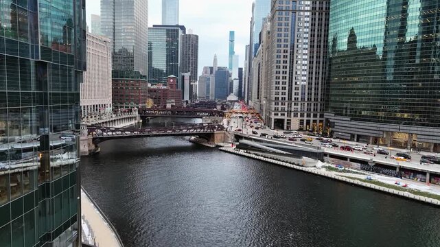 Aerial view low over snowy Chicago bridges along the river in cloudy downtown