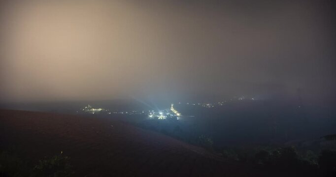 Timelapse of a rural town blanketed by the fog at night
