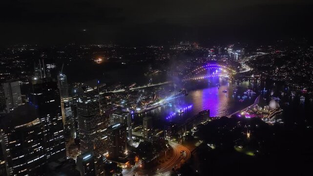 Wide Aerial Drone View of Sydney at Night, Fireworks Exploding Over the Harbour and City Skyline in Australia