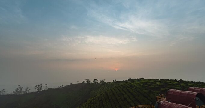 Timelapse of a foggy sunrise on a tea plantation hill