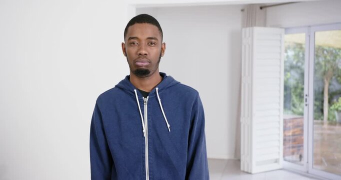 High speed photography for dynamic scenes, man in blue hoodie standing indoors, looking displeased o