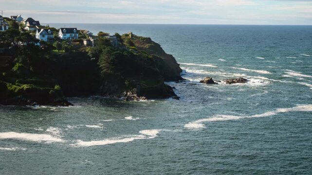 Sea foam moving with the tide, Polruan headland, Fowey, Cornwall, UK. Probably due to the breakup of algal blooms at the end of summer, or eutrophication from agricultural runoff. Zoom out