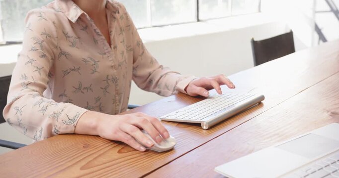 Typing on wireless keyboard at office desk, focusing on work