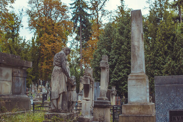 Fototapeta premium Ancient European cemetery with stone angels and historic tombstones