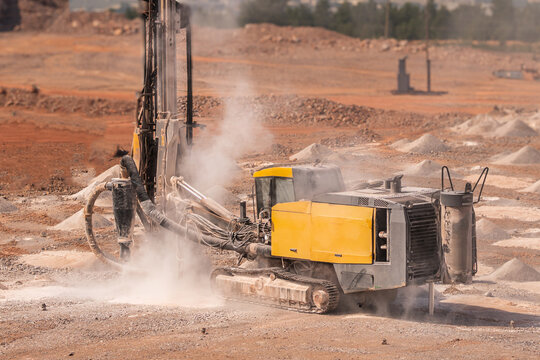Drill rig drilling blast holes in an open pit mine, heavy mining equipment for mineral extraction, quarry operations and surface mining
