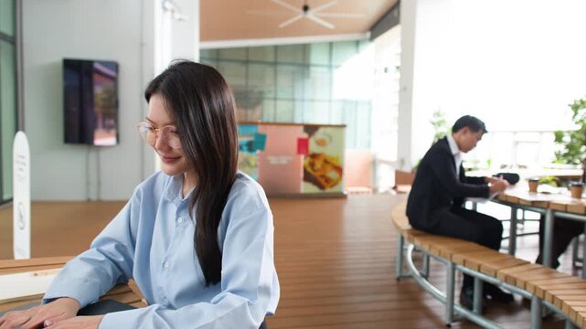 Asian Woman Working on Laptop in Modern Coworking Space