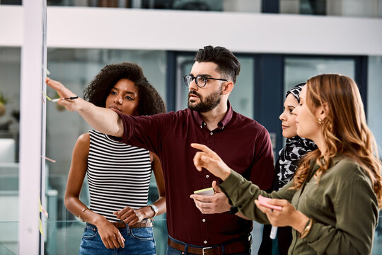 Creative, brainstorming and group with sticky notes in office, point or idea for marketing strategy. Business, collaboration and people with info, discussion and planning for campaign with colleagues