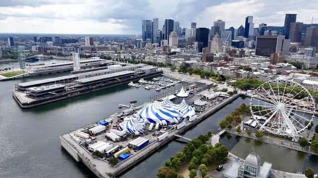 Cirque du Soleil blue-white tent at Montreal Old Port with city skyline in background. 24th of August 2025 drone flight