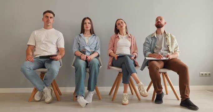 Adult participants attend a training seminar workshop. Four people sit with notebooks, creating an attentive audience for education lecture. Group learning and professional development concept.