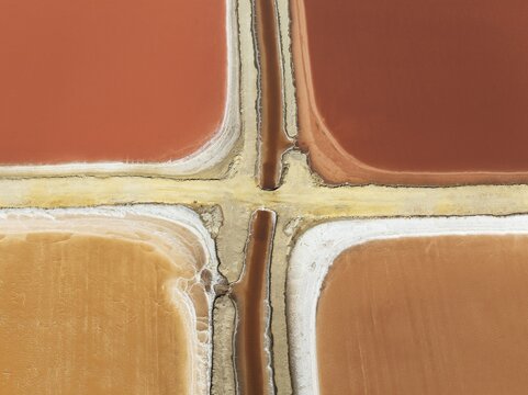Saline ponds at the Bonanza salt works near Sanl&uacute;car de Barrameda. The reddish colour depends on the level of salinity and is directly caused by the algae Dunaliella salina and brine shrimp. Aerial view. Drone shot. C&aacute;diz province, Andalusia, Spain