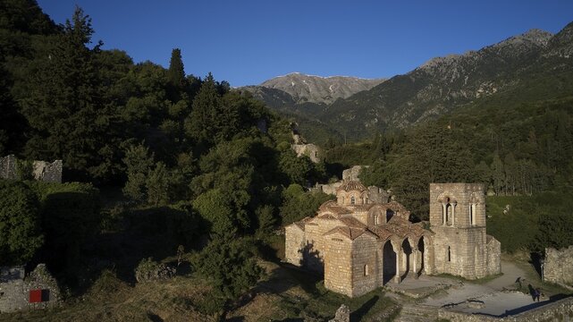 Church of Agia Sophia from the 14th century A.D. Stone church and ruins surrounded by green vegetation at the foot of the mountains, Mystras, Mistra, UNESCO World Heritage Site, Medieval Byzantine ruined city, northwest of Sparta, foothills of the Tyagetos Mountains, Peloponnese, peninsula, Greece