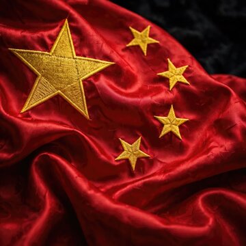 Close-up of the Chinese Flag with Golden Stars on Red Silk Fabric.