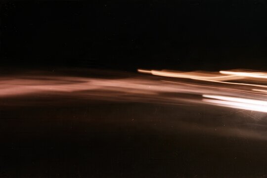 Abstract warm horizontal light trails sweeping across dark vintage film background with grain, motion blur and cinematic long exposure texture