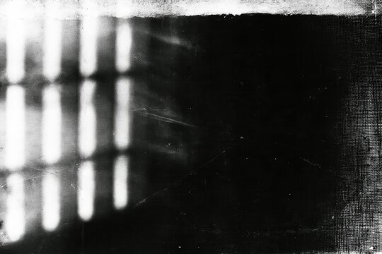 Distressed black and white analog film frame with glowing window reflection, worn edges, grain and scratches for vintage cinematic texture overlay