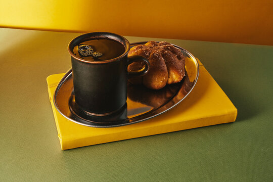 Black Coffee Mug with Sugared Pastry on Silver Tray