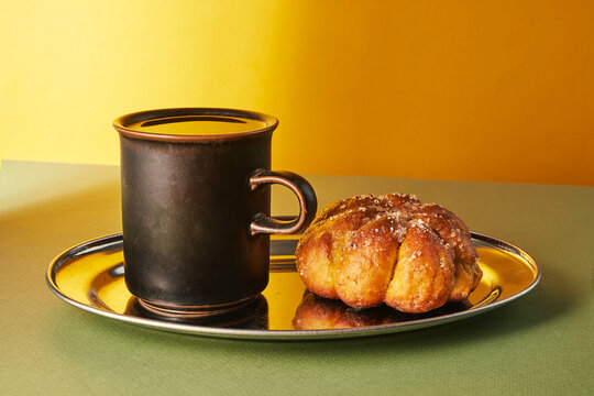 Black Coffee Mug with Sugared Pastry on Silver Tray