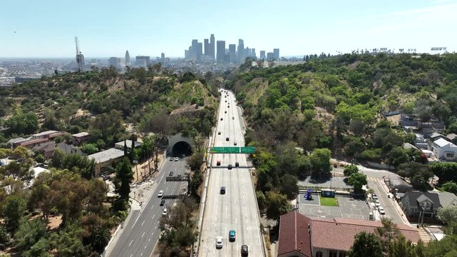 Los Angeles, California, USA - Wide pullback drone aerial view of busy Interstate 5 receding from the Downtown skyline next to Elysian Park. Heavy freeway traffic fills multiple highway lanes