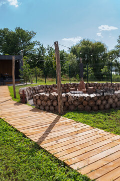 Cozy vacation cottage with a lawn, a wooden walkway, and a fire pit. Outdoor getaway, holiday retreat. vertical
