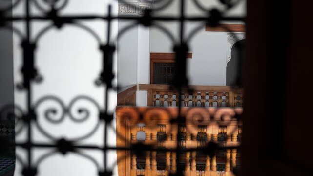 モロッコの伝統建築、錬鉄の装飾窓越しに見る中庭と木彫りの回廊（Morocco Wrought Iron Window and Riad Courtyard）