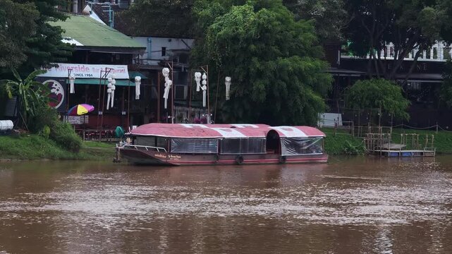  wooden boat used for customer service and transportation at a riverside restaurant.