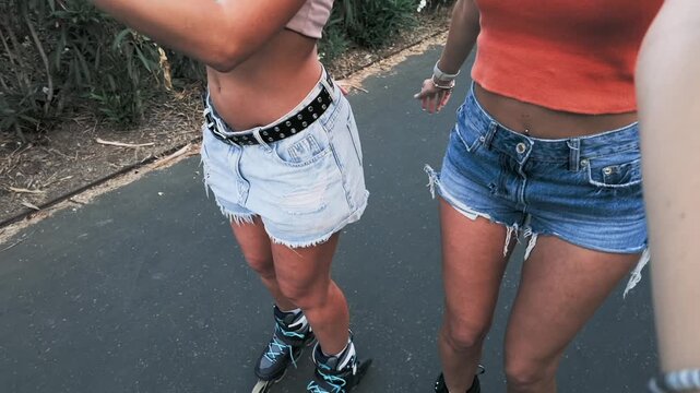 Two female friends taking selfie video while rollerskating