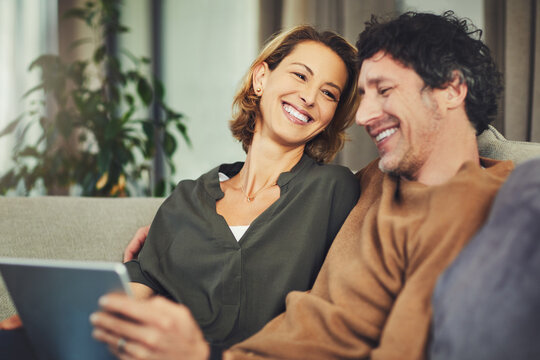 Love, streaming and tablet with couple on sofa in living room of home for subscription signup. App, download and smile with mature people in apartment together to search for online membership options