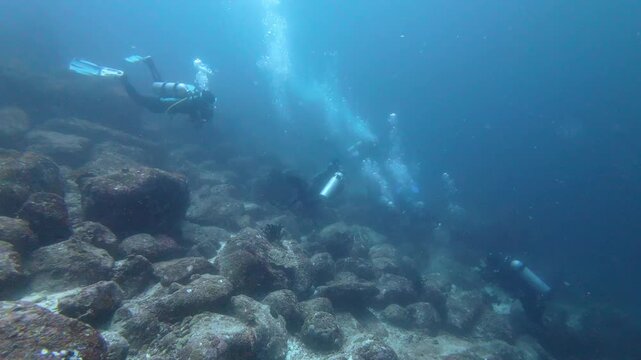Weh Island, Indonesia: Underwater footage of divers in current during dive in Seulako drift, famous dive site with rock topography in Weh Island of Sabang, Aceh, Indonesia