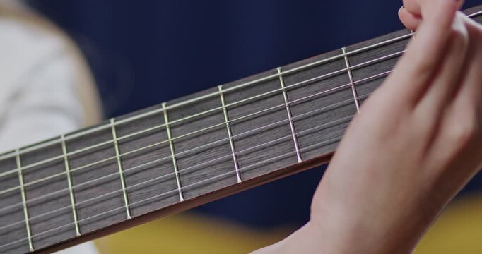 Close up view of guitarist hands placing fingers on guitar fretboard