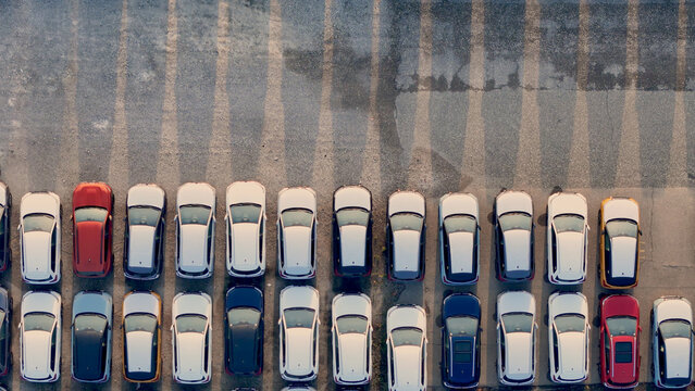 Rows of new luxury SUVs parked in an outdoor staging yard awaiting transport, illustrating global commerce, automotive logistics, and import export industry operations