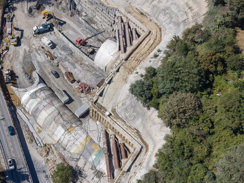 Aerial view of a construction site featuring a large concrete tunnel entrance, heavy machinery, and excavation work surrounded by lush greenery in Istanbul, Istanbul, Turkiye.