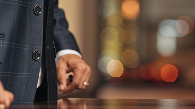 Businessman hand putting a coin into a glass piggy bank for financial savings