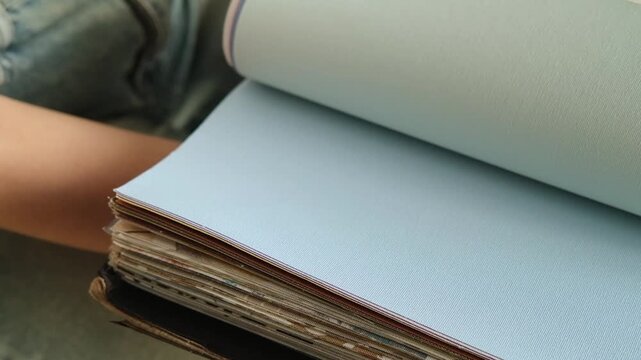 Close up of a female hand browsing fabric samples to choose material for roller blinds for home Interior design and window treatment concept focused on selecting colors textures and fabrics for decor